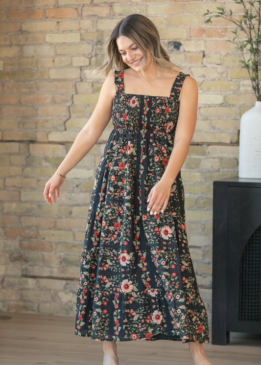 Black floral sleeveless midi dress with smocked bodice and ruffle straps in natural light
