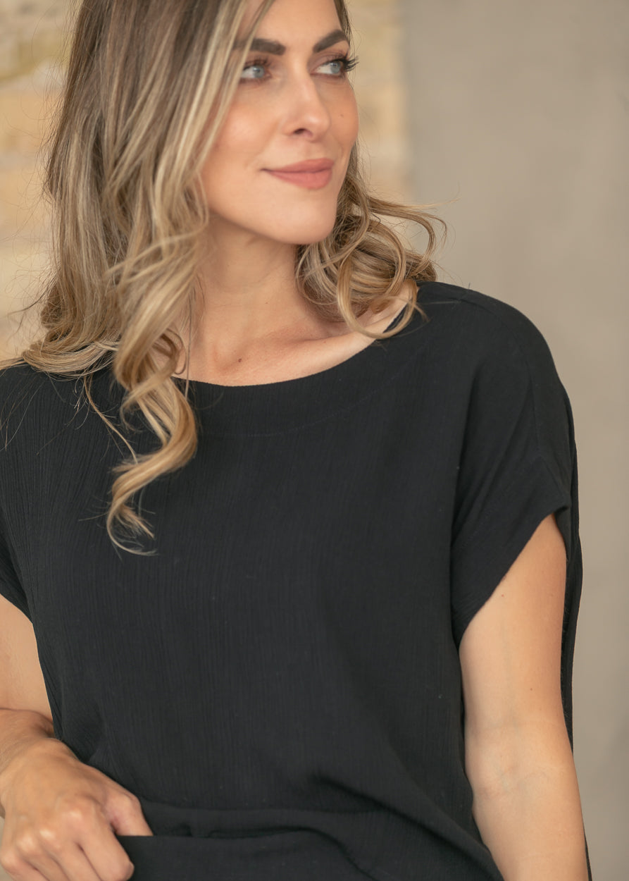 Close view of black gauze top with relaxed fit and textured fabric