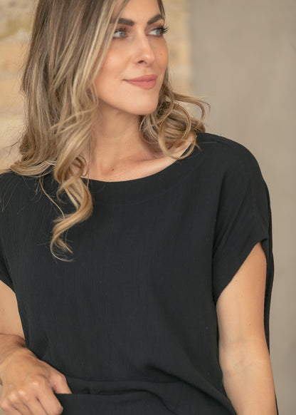 Close view of black gauze top with relaxed fit and textured fabric