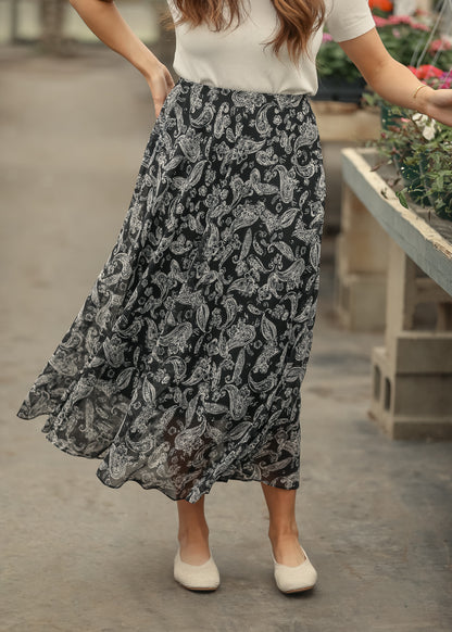 Black paisley maxi skirt paired with neutral woven flats