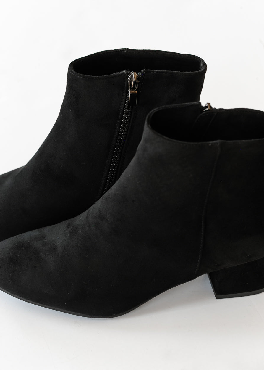 Black pointed toe boots shown from above with side zippers and low block heels.
