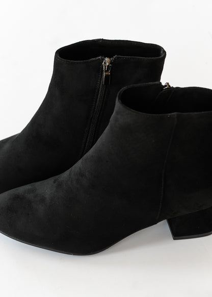 Black pointed toe boots shown from above with side zippers and low block heels.