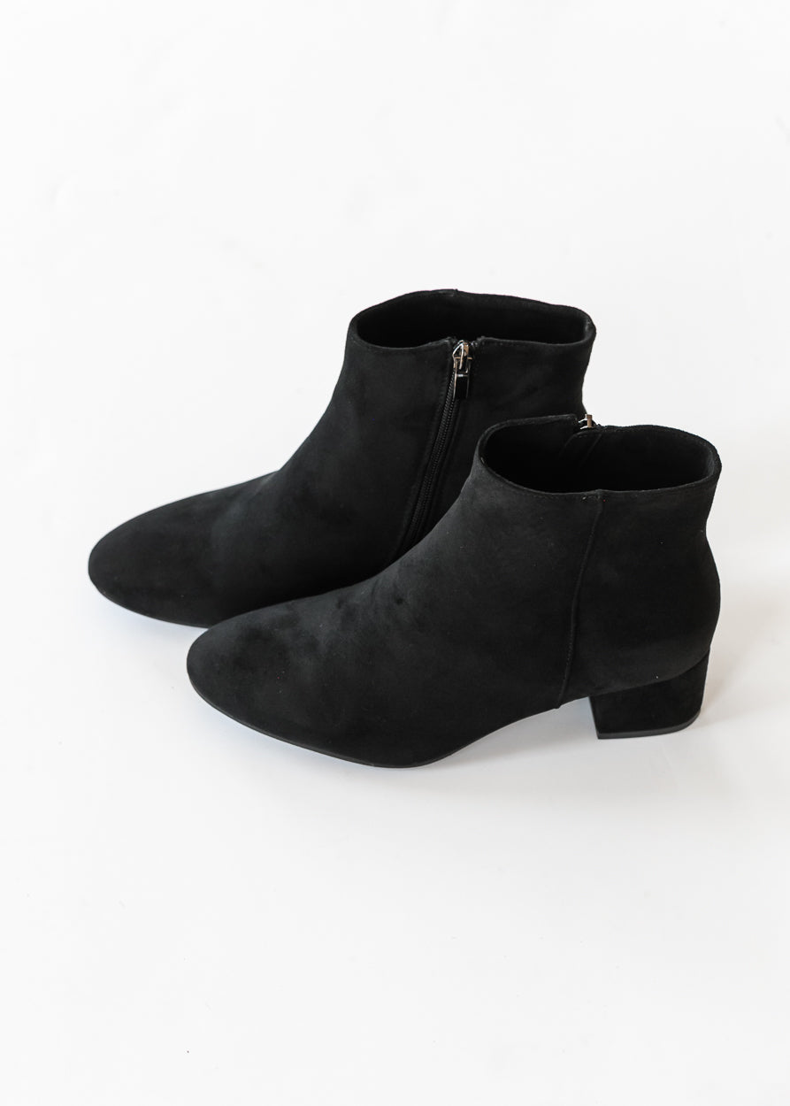 Black low block heel ankle boots with pointed toes on a white background.