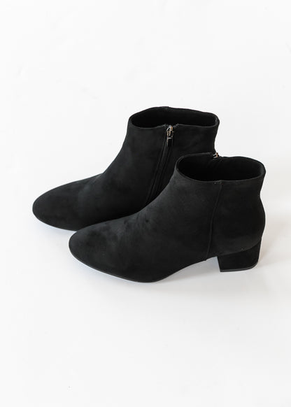 Black low block heel ankle boots with pointed toes on a white background.