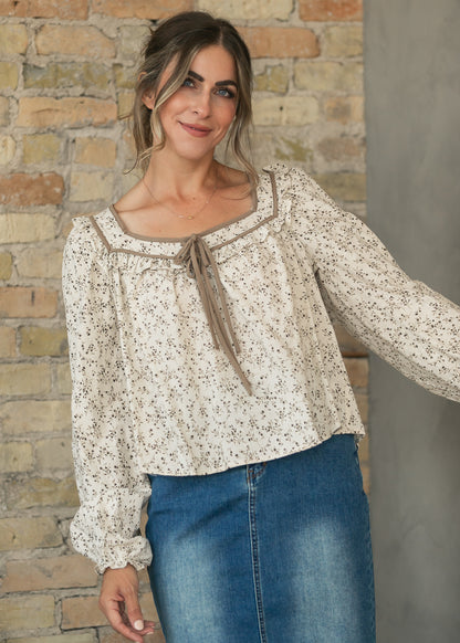 Long sleeve botanical blouse with a loose hip-length fit, styled with a knee-length denim skirt.
