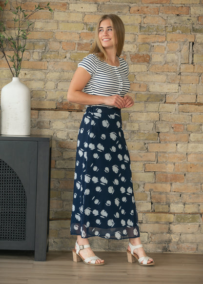 Navy and white striped cardigan with cap sleeves paired with a flowing navy midi skirt