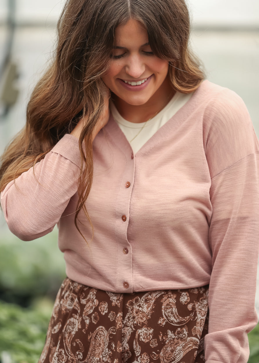 Mauve lightweight v neck cardigan layered over a brown paisley maxi skirt