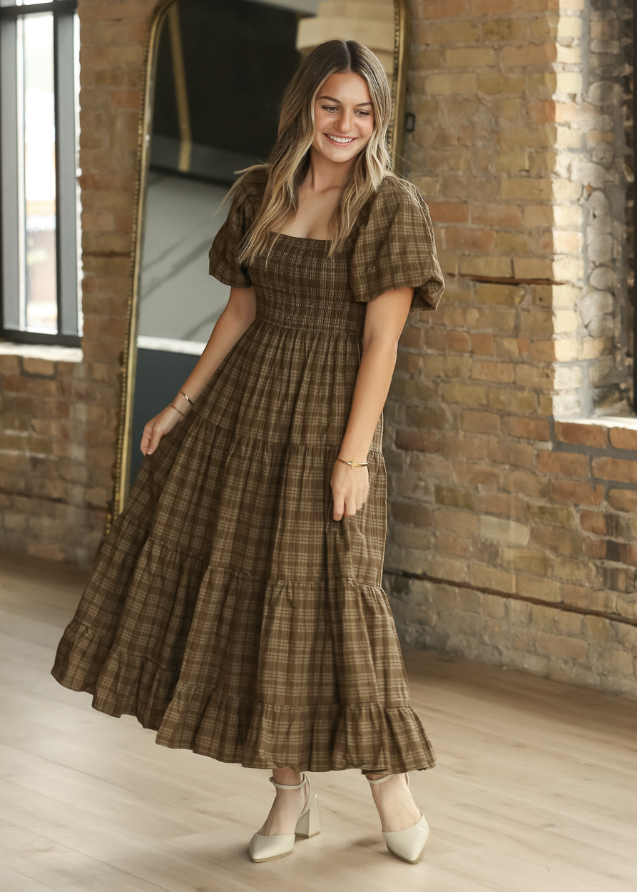 Brown plaid smocked midi dress with square neckline, puff sleeves, and tiered cotton skirt.