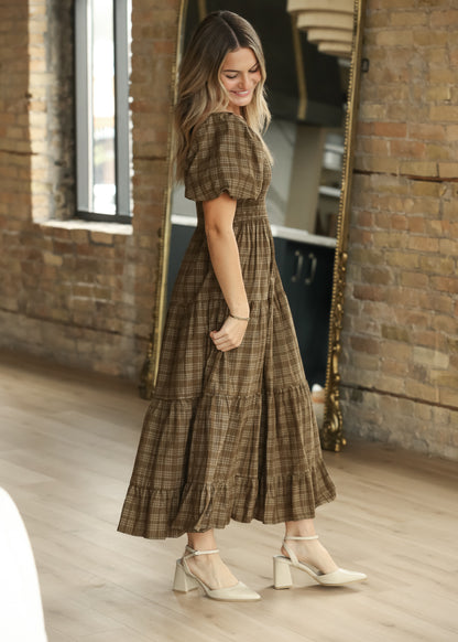 Brown plaid puff sleeve midi dress shown from the side with smocked bodice and tiered hem.