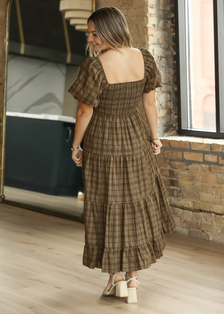 Back of brown plaid midi dress showing the smocked bodice and flowing tiered skirt.