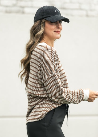 Brown striped ribbed pullover styled with a black athletic maxi skirt and sneakers.