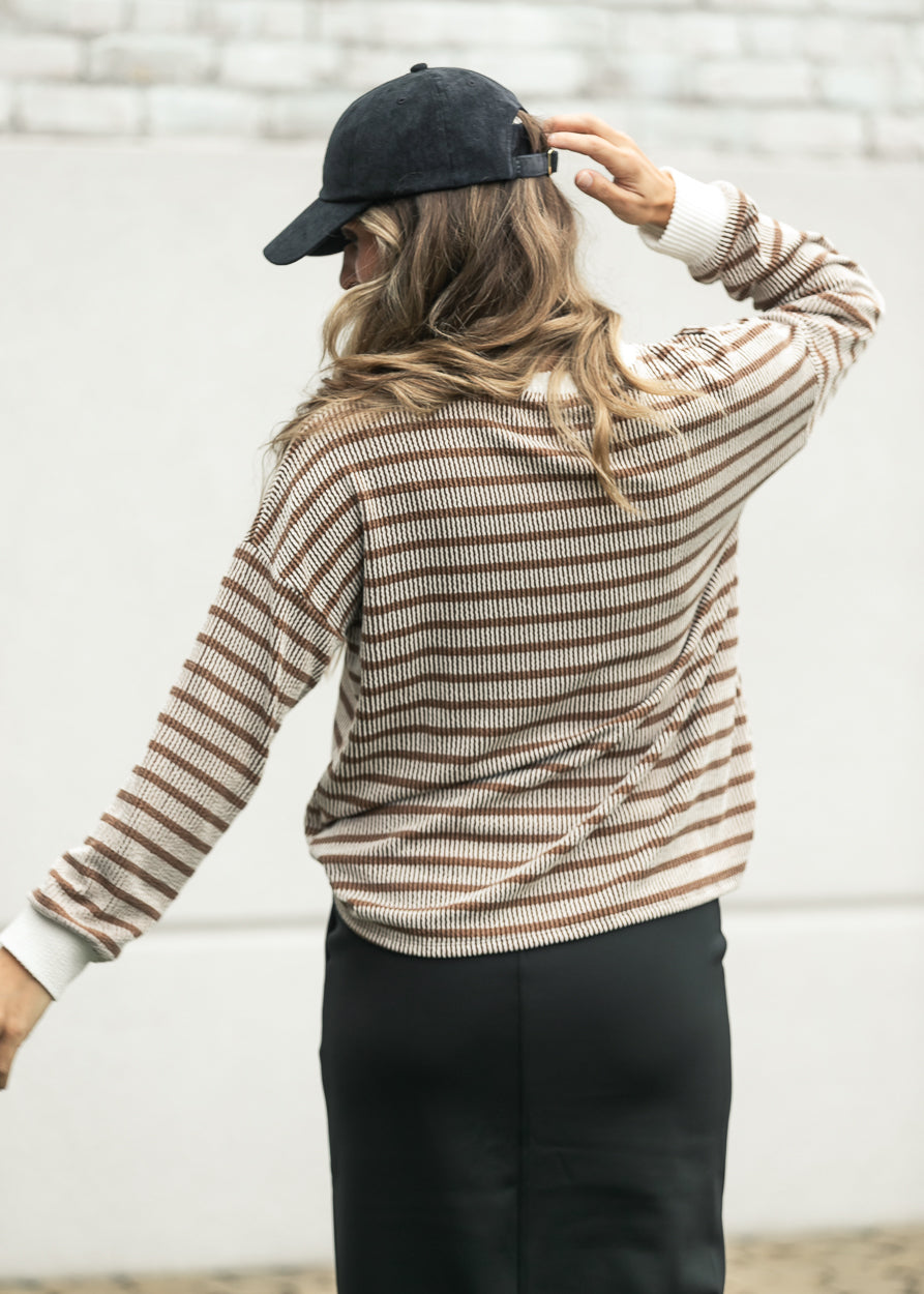Brown ribbed long sleeve top with a loose fit and cream contrast trim.