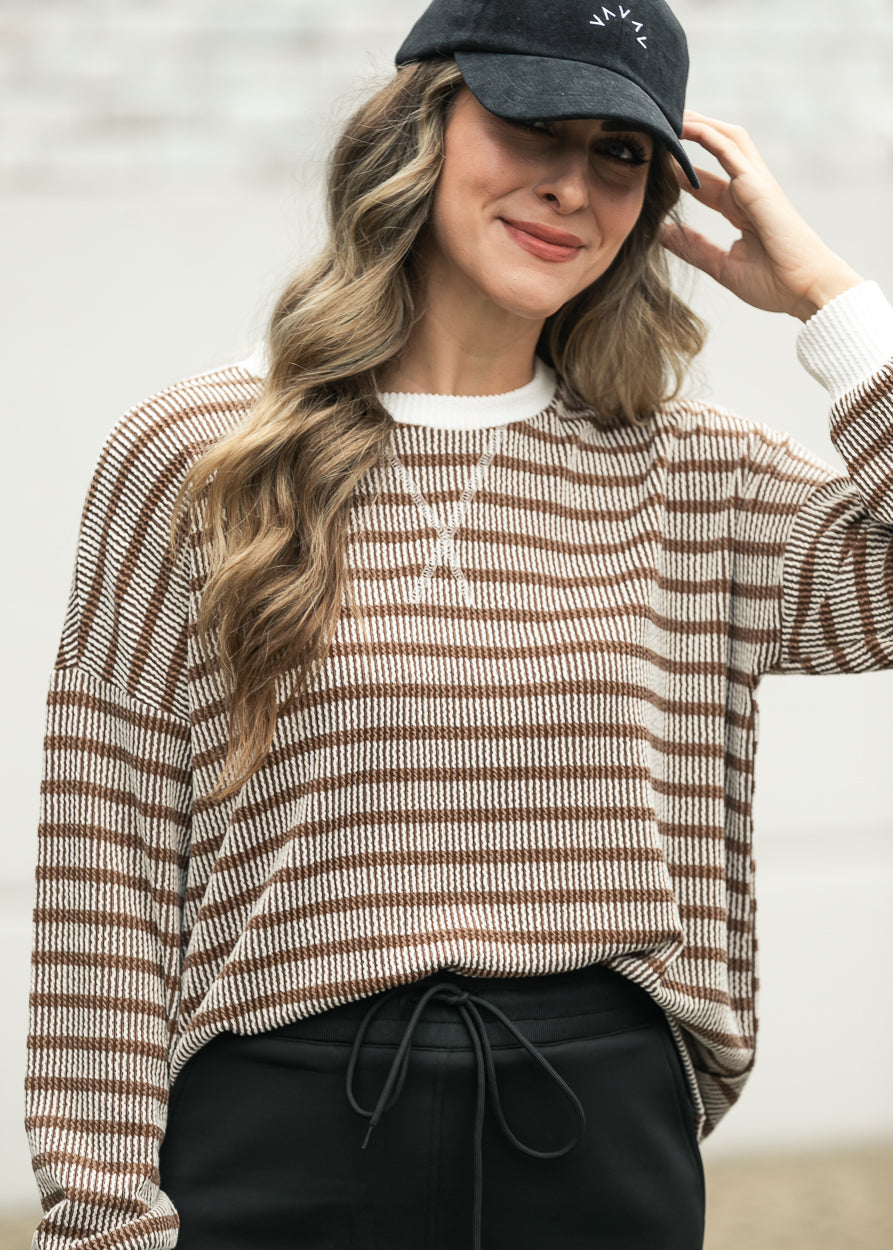 Brown and cream striped pullover with drop shoulders styled with a black maxi skirt.