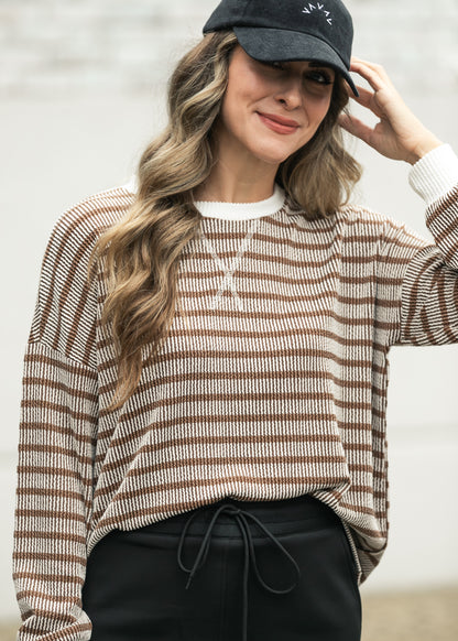 Brown and cream striped pullover with drop shoulders styled with a black maxi skirt.