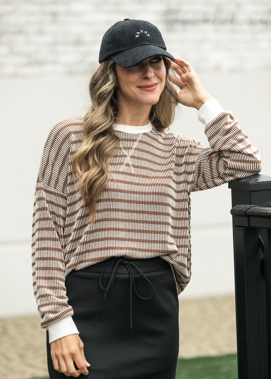 Brown striped long sleeve pullover styled with a black drawstring maxi skirt.