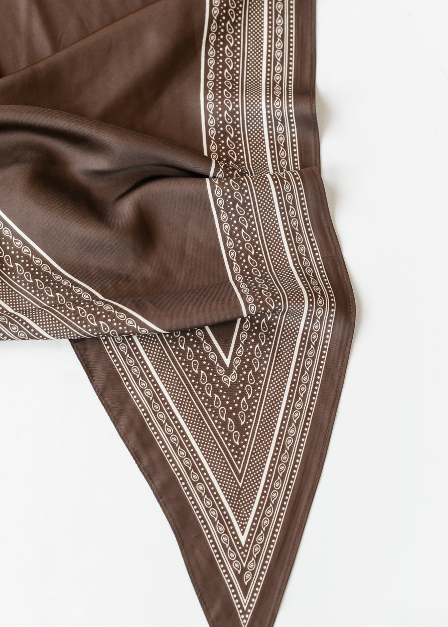 Brown silk-cotton triangle scarf with cream striped bandana border print, shown draped on a white background.