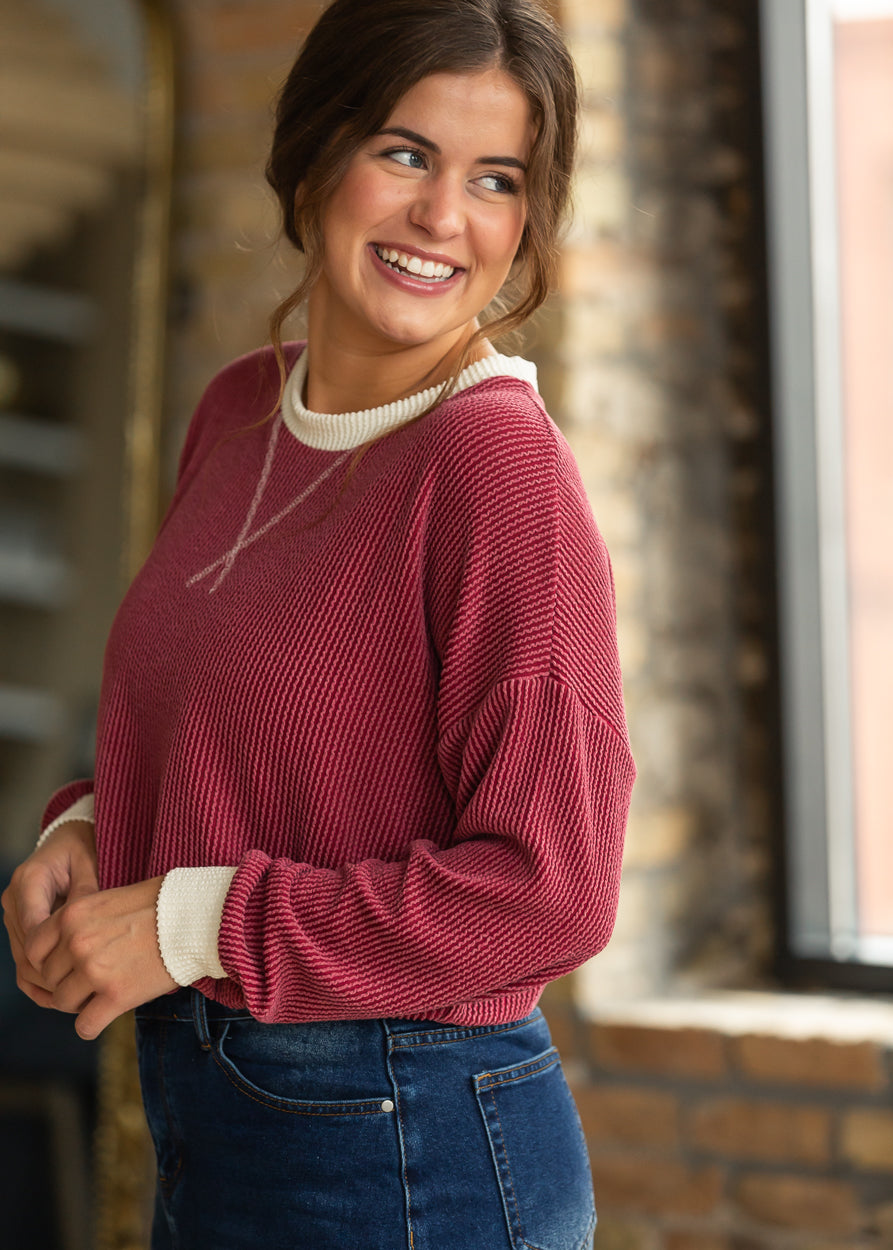 Burgundy ribbed pullover with cream trim styled with a dark wash denim maxi skirt.