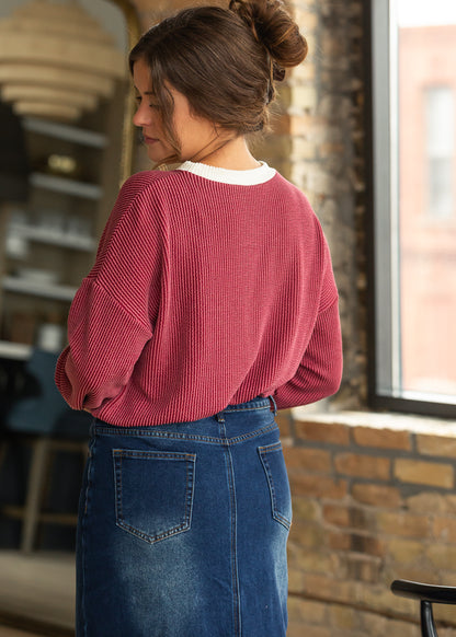 Back detail of burgundy ribbed pullover showing drop shoulders and cream contrast neckline.