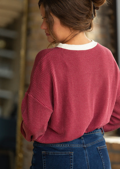 Back detail of burgundy ribbed pullover showing drop shoulders and cream contrast neckline.