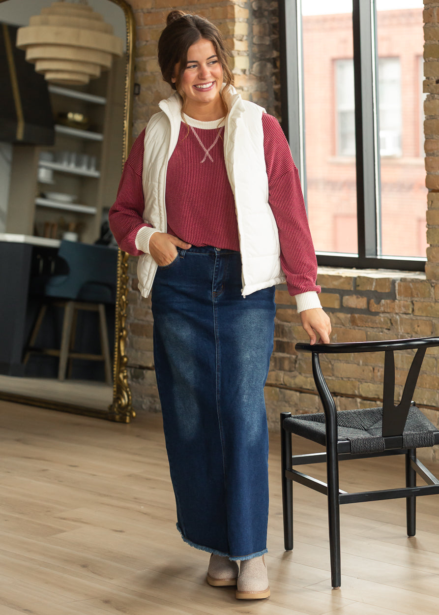 Burgundy ribbed top with cream contrast cuffs styled with a puffer vest and denim maxi skirt.