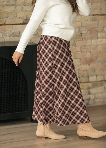 Side view of burgundy plaid A-line midi skirt showing the flowing hem and cream plaid pattern.
