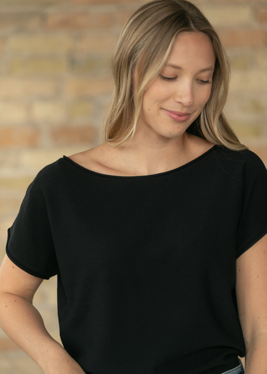 Black relaxed fit knit top with boat neckline and cap sleeves.