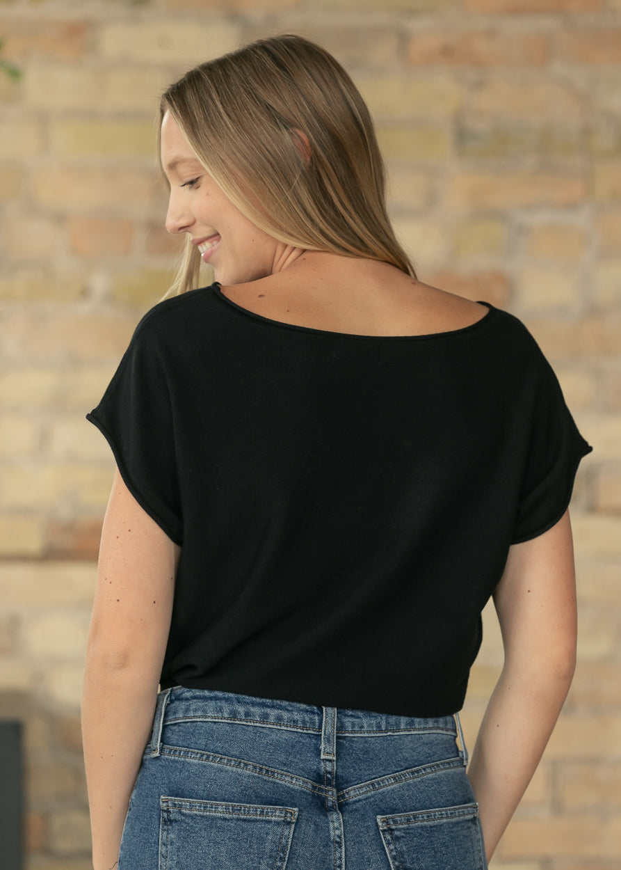 Back view of black knit top showing relaxed fit and clean silhouette.