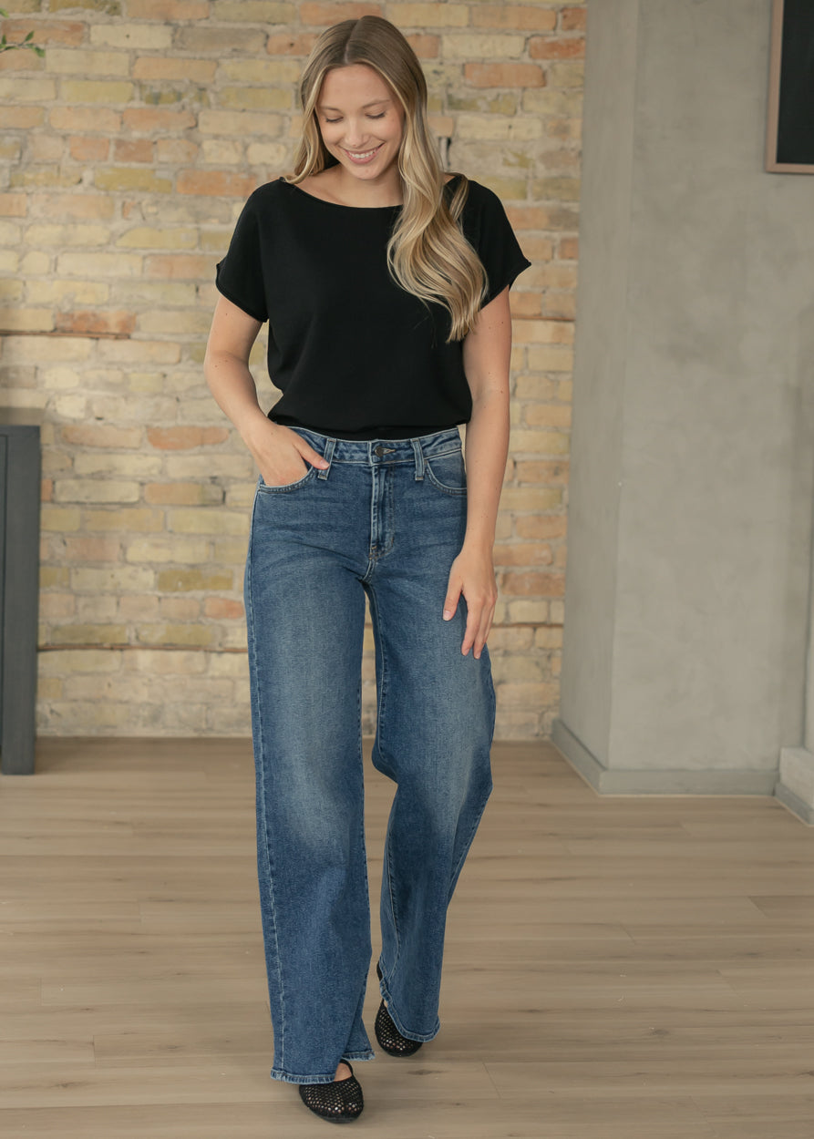 Black cap sleeve boat neck knit top styled with medium wash wide leg jeans.