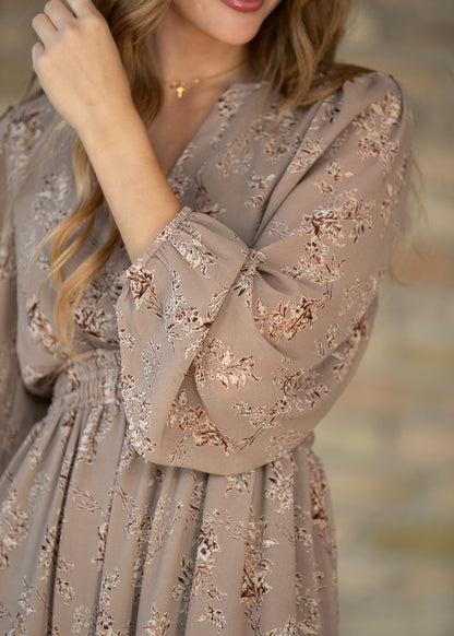 Close-up of brown floral maxi dress showing the long sleeve, floral print, and gathered cuff.