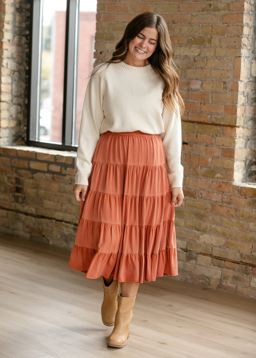 Two-tone rust midi skirt styled with an ivory sweater and tan boots for an everyday fall look.