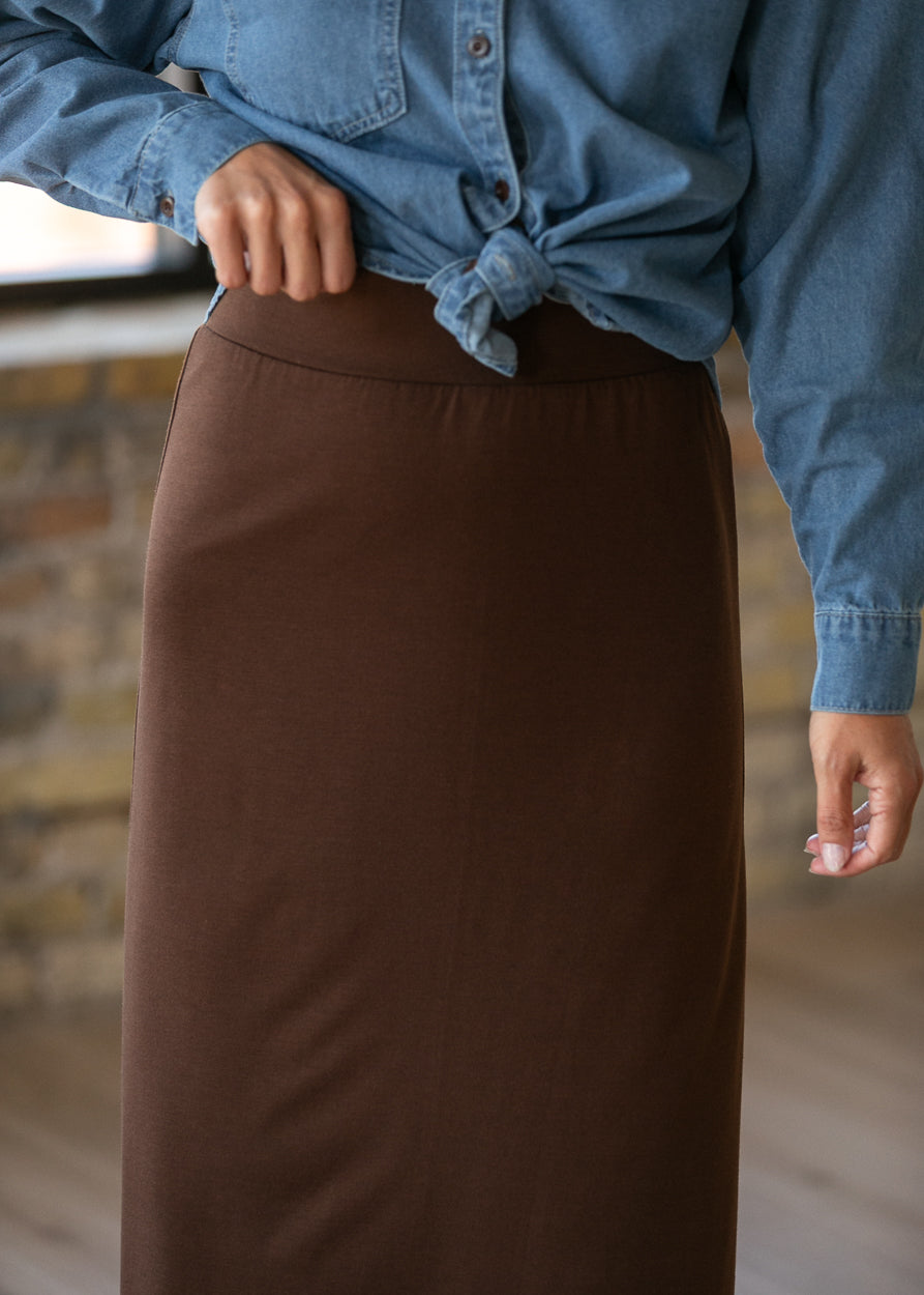 Close-up of the chocolate brown knit maxi skirt showing the wide elastic waistband and smooth finish.
