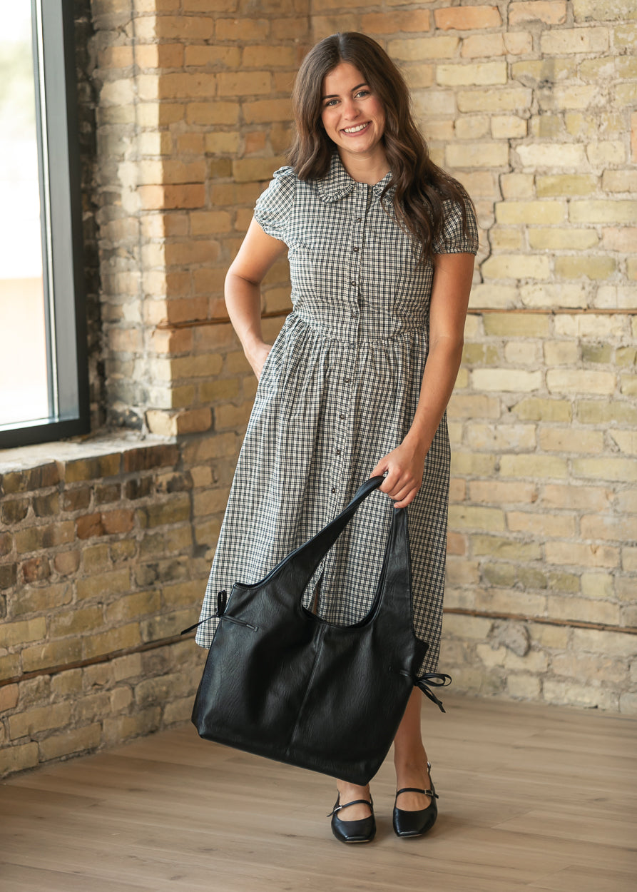 Dark navy gingham button-front midi dress styled with black flats and a black slouch tote.