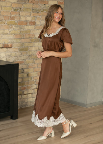 Chocolate brown midi dress with cream lace neckline and scalloped lace hem, styled with cream heels.