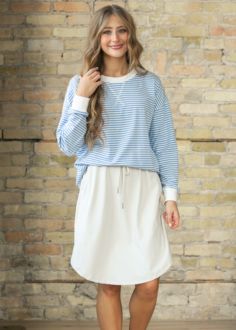 Cornflower blue striped loose fit sweater styled with a neutral drawstring skirt.