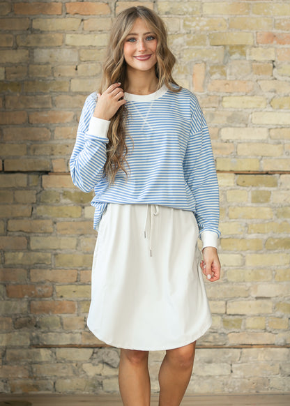 Cornflower blue striped loose fit sweater styled with a neutral drawstring skirt.