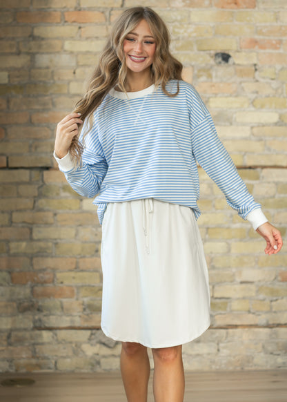 Cornflower blue and white striped crewneck sweater styled with a bone white knee-length skirt.