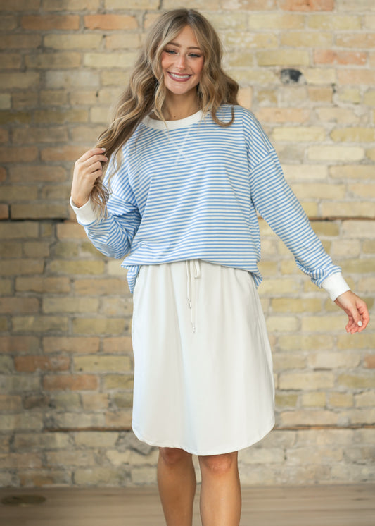 Cornflower blue and white striped crewneck sweater styled with a bone white knee-length skirt.