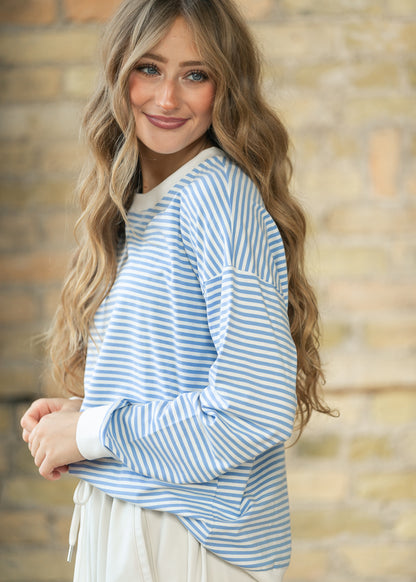 Close view of cornflower blue mini striped sweater with dropped shoulder seam and contrast white trim.