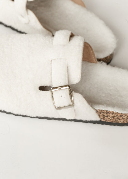 Ivory sherpa clogs styled with a denim skirt, shown on foot outdoors.