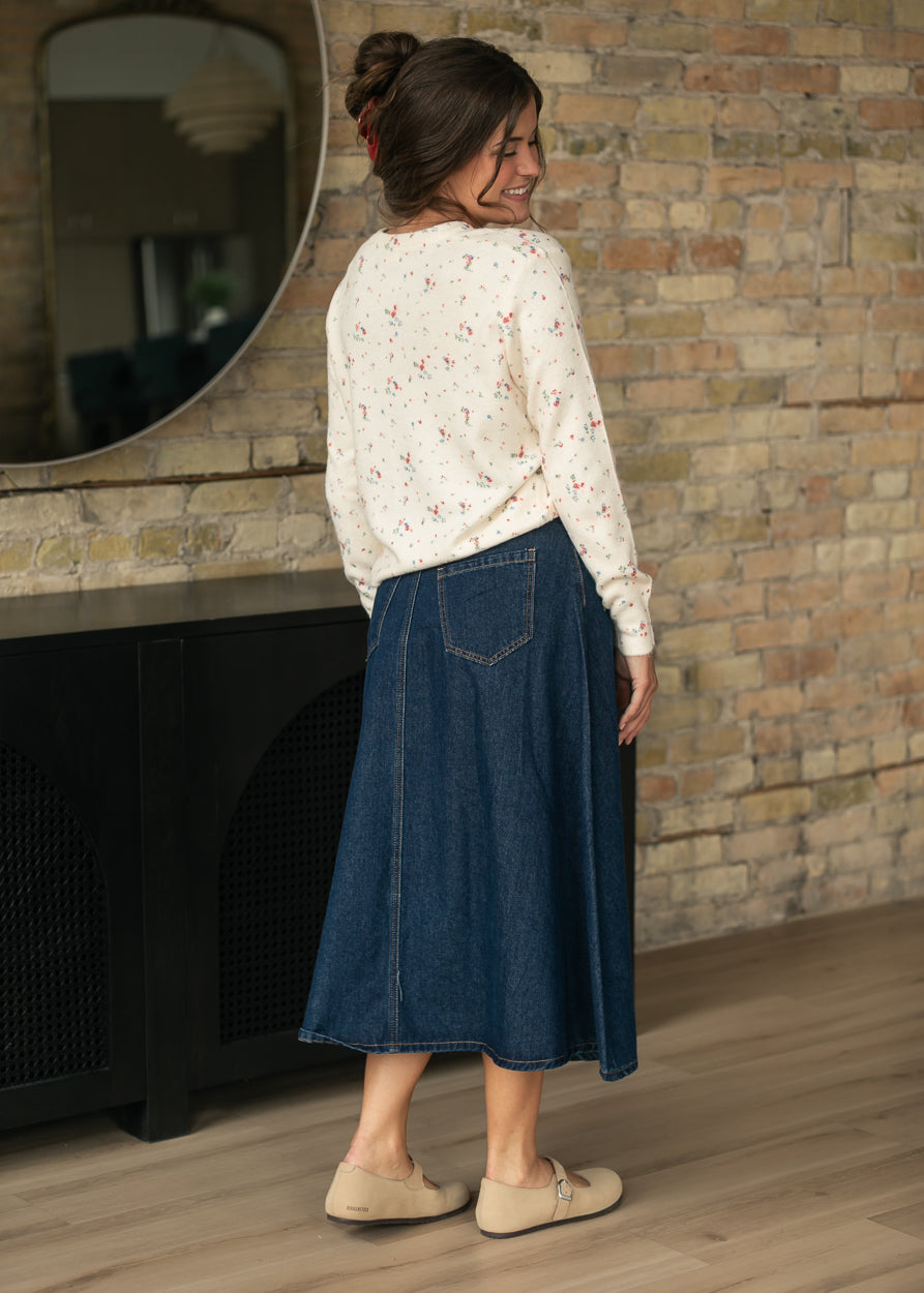 Back of dark indigo denim midi skirt showing patch pockets and softly flared silhouette.