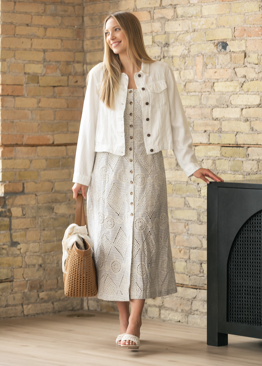 Close view of embroidered eyelet pattern and tortoise-style buttons