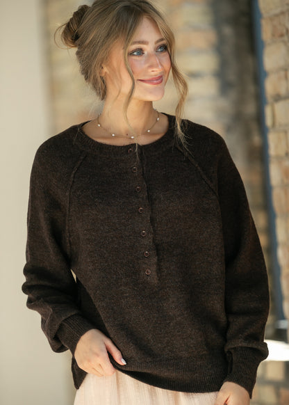 Close-up of the dark brown henley sweater's button placket and crew neckline.