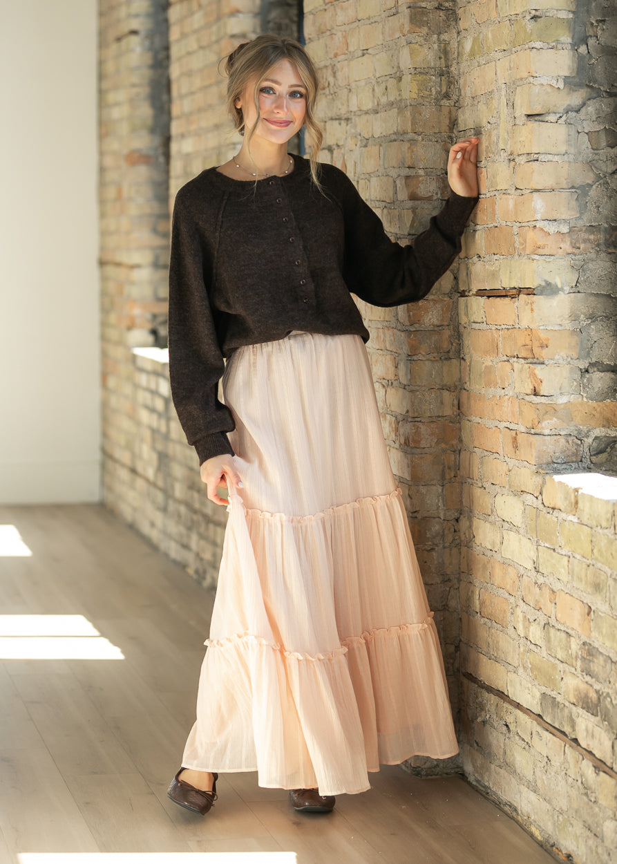 Dark brown henley sweater styled with a blush tiered maxi skirt and brown flats for a full-length look.