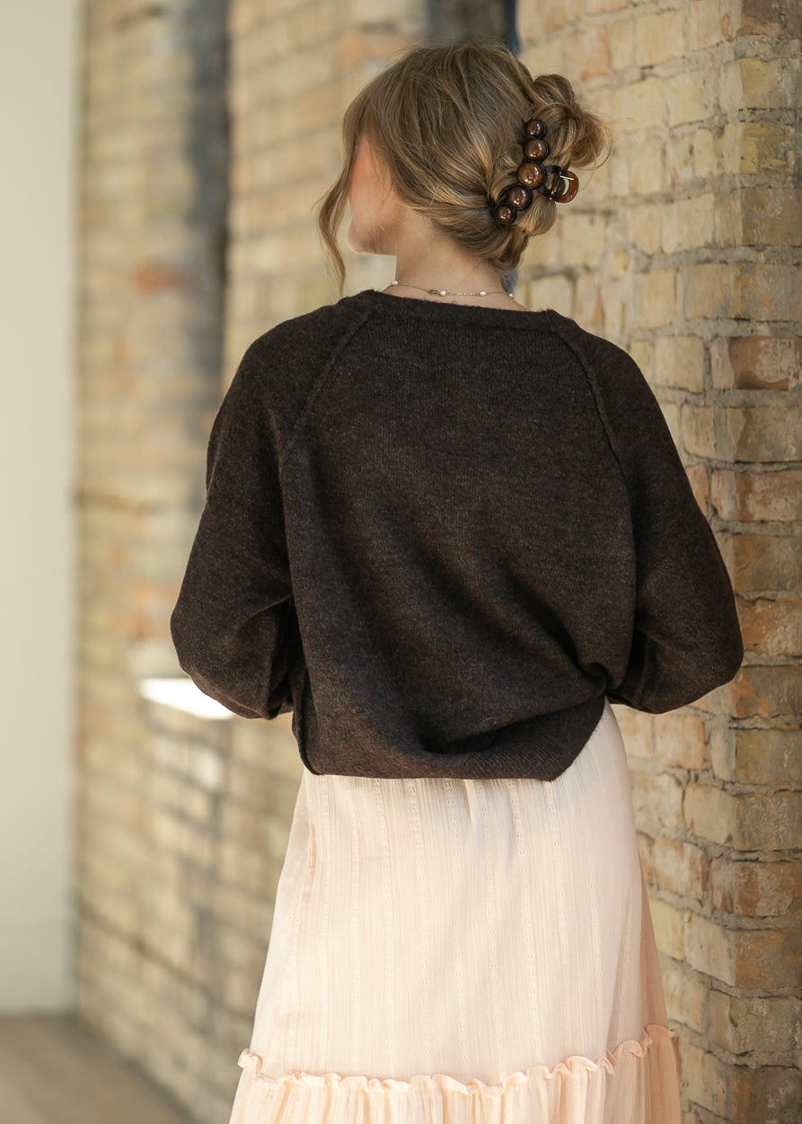 Back of the dark brown henley sweater, styled with a blush tiered maxi skirt.