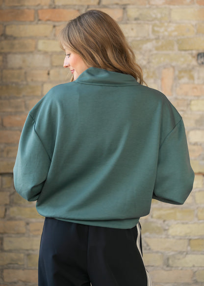 Back of the dark forest quarter zip sweatshirt showing the dropped shoulder seams and collar.