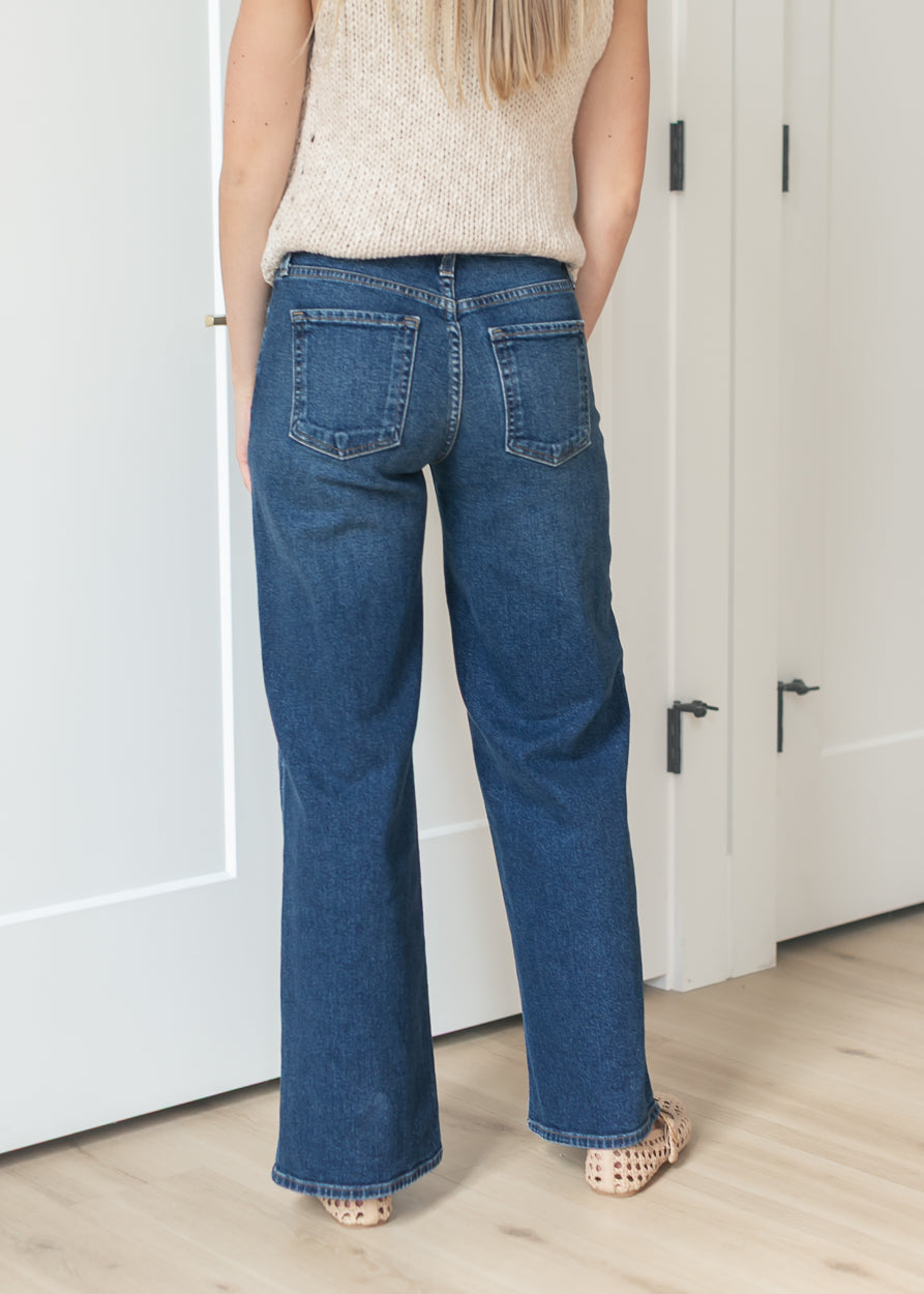 Back view of dark wash wide leg jeans highlighting pocket placement and relaxed fit.