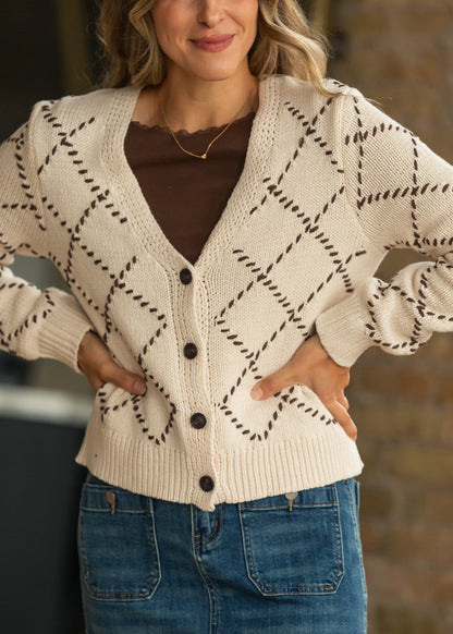 Cream diamond stitch cardigan with brown contrast stitching, V-neckline, and functional buttons.