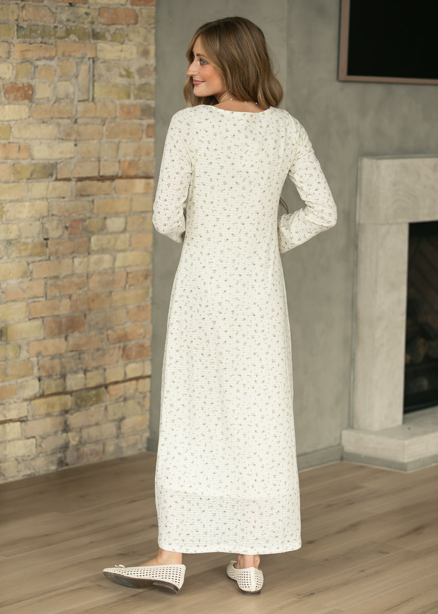 Full back view of cream long sleeve maxi dress with tiny pink florals and ankle-length silhouette.