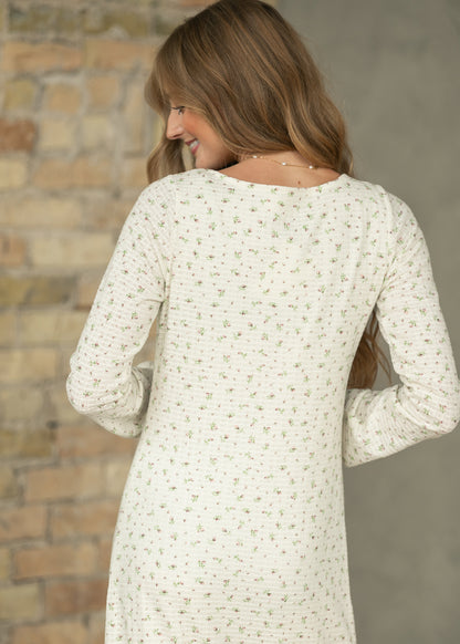 Back of cream floral maxi dress showing long sleeves, soft textured fabric, and delicate floral print.