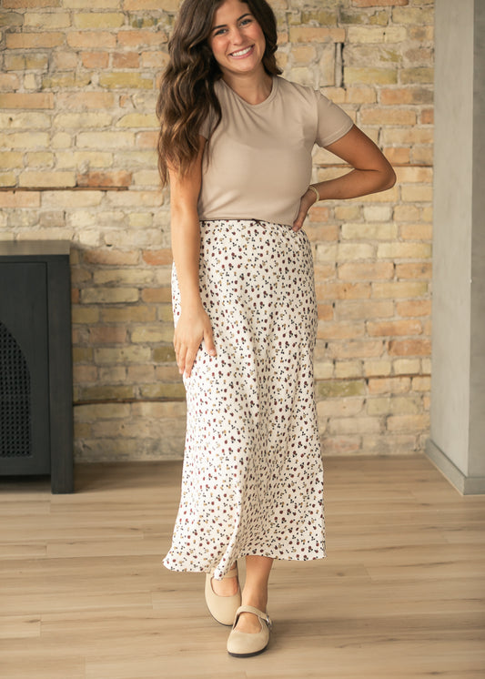 Cream ditsy floral maxi skirt styled with a taupe short sleeve top and neutral Mary Jane shoes.